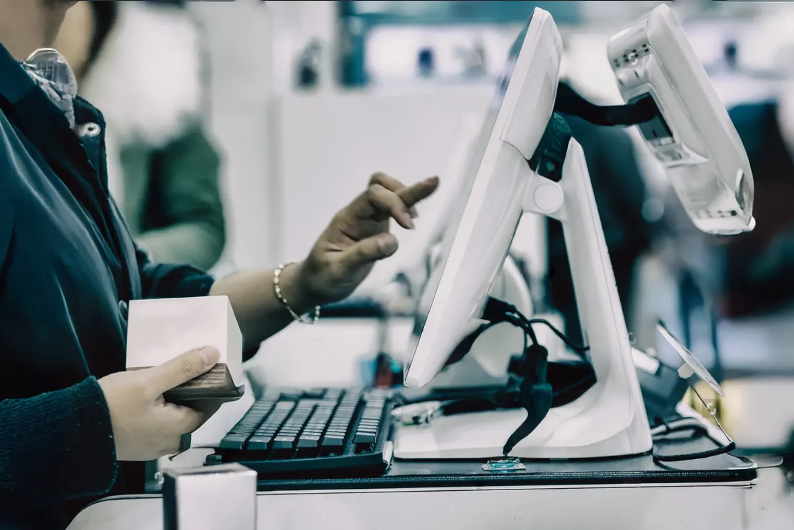 Photo of a woman processing an order at a POS terminal